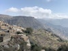 Von Weitem kaum als Hotelanlage zu erkennen – Oberhalb eines gewaltigen Canyons liegt das Anantara Al Jabal Al Akhdar Resort auf einem Plateau, behutsam in die Natur integriert (im Hintergrund), vorne das fast vollständig verlassene Bergdorf Ash Shirayjah