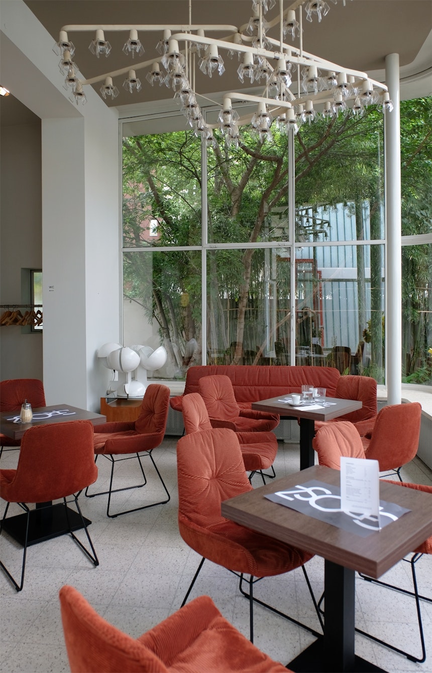 Café Interior mit Ausblick auf den wundervollen Garten und  die großzügige Terrasse, Sessel und Bank Leya, Freifrau, Design Birgit Hoffmann & Christoph Kahleyss