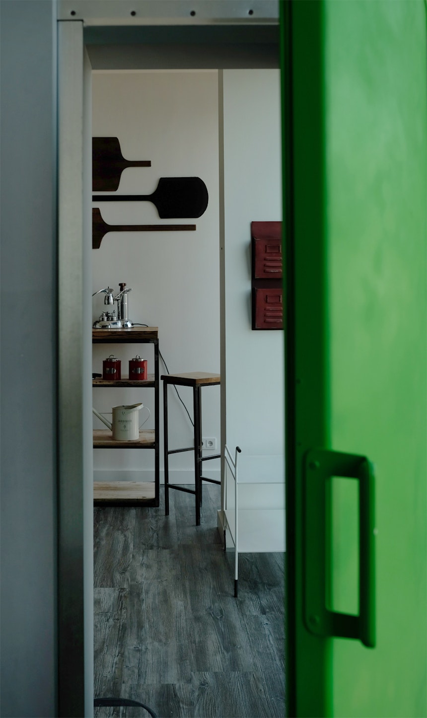 Die grüne Kühlschrank-Tür der Küchenzeile führt in einen Besprechungsraum
