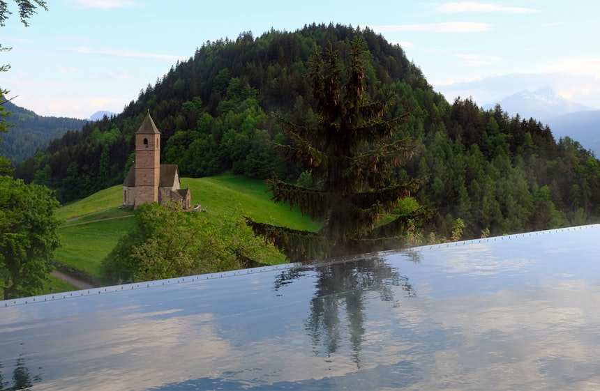  Schwimmen mit Sicht auf Wiesen, Wälder, Berge und die Kirche von Hafling