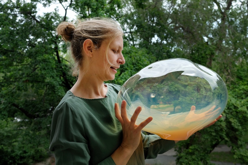 Designerin Simone Lüling mit einem irisierenden Lampenglas