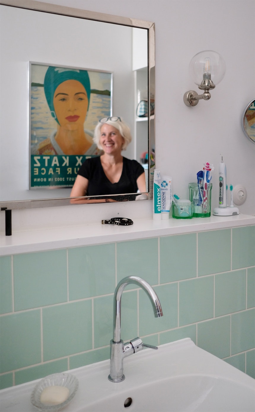 Das gerade frisch renovierte Badezimmer mit Fliesen im Fifties-Look, Retro-Wandleuchten & Julia im Vintage-Spiegel