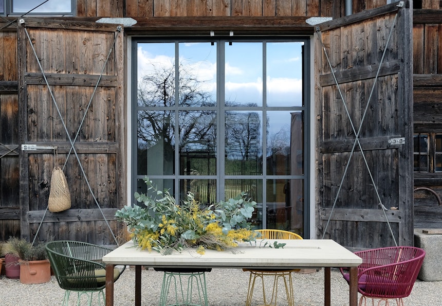 Outdoor-Tisch Tawila aus Beton & Stahl (tan tan), Stühle (Ames Design) im Garten der ausgebauten Scheune aus dem 18. Jahrhundert, die Rinne in der Tischplatte kann bepflanzt und zur Getränkekühlung verwendet werden