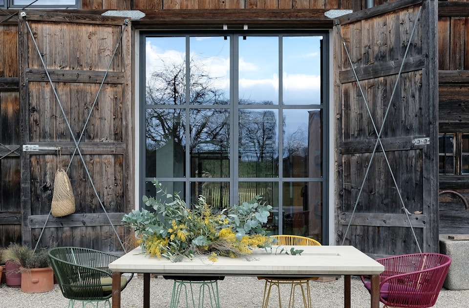 Outdoor-Tisch Tawila aus Beton & Stahl (tan tan), Stühle (Ames Design) im Garten der ausgebauten Scheune aus dem 18. Jahrhundert, die Rinne in der Tischplatte kann bepflanzt und zur Getränkekühlung verwendet werden